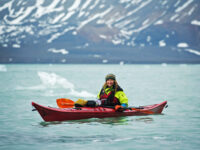 Quark Expeditions_Arctic Saga_Fair Isle, Faroes, and Spitsbergen_Birds & Bears_kayakers_svalbard_14_july_glacier_Credit_AcaciaJohnson