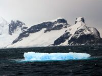 Surreal looking image of a blue iceberg in a somewhat dramatic Antarctic background_Miss Scuba